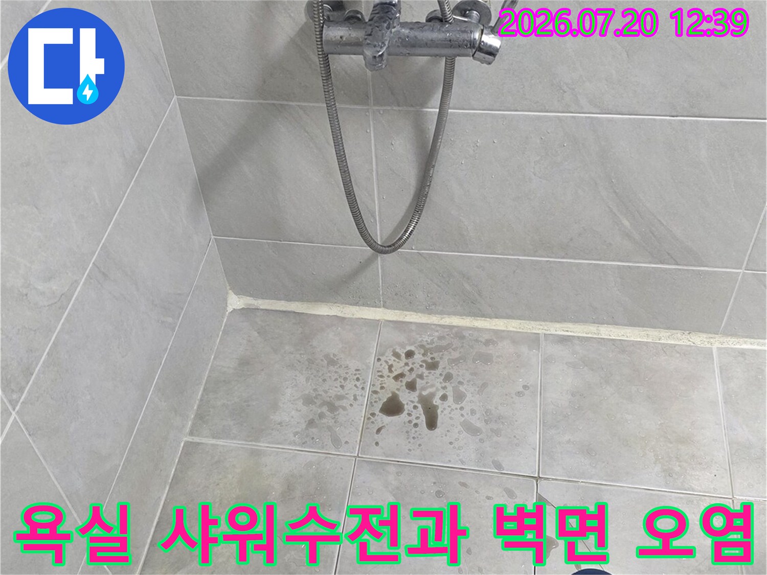 욕실 내부에 설치된 샤워 수전-배관 연결 부위와 주변 타일의 갈색 얼룩 모습