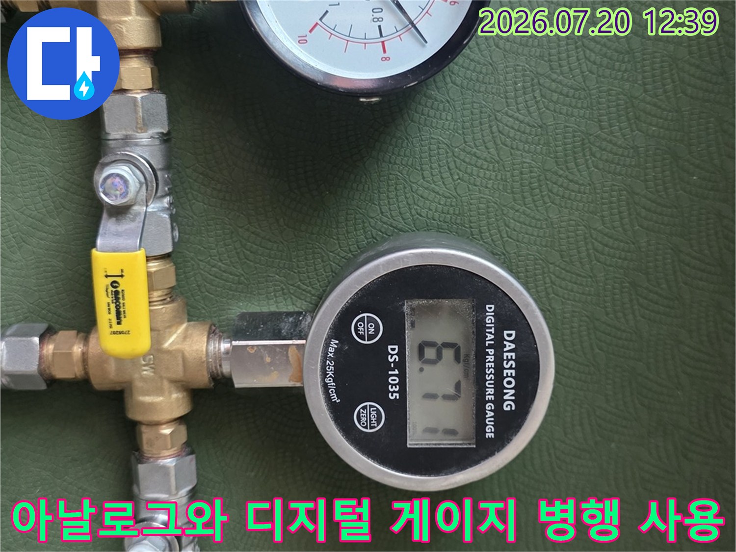 투명 호스와 황동 밸브 그리고 두 개의 압력 측정기가 연결된 배관 시스템
