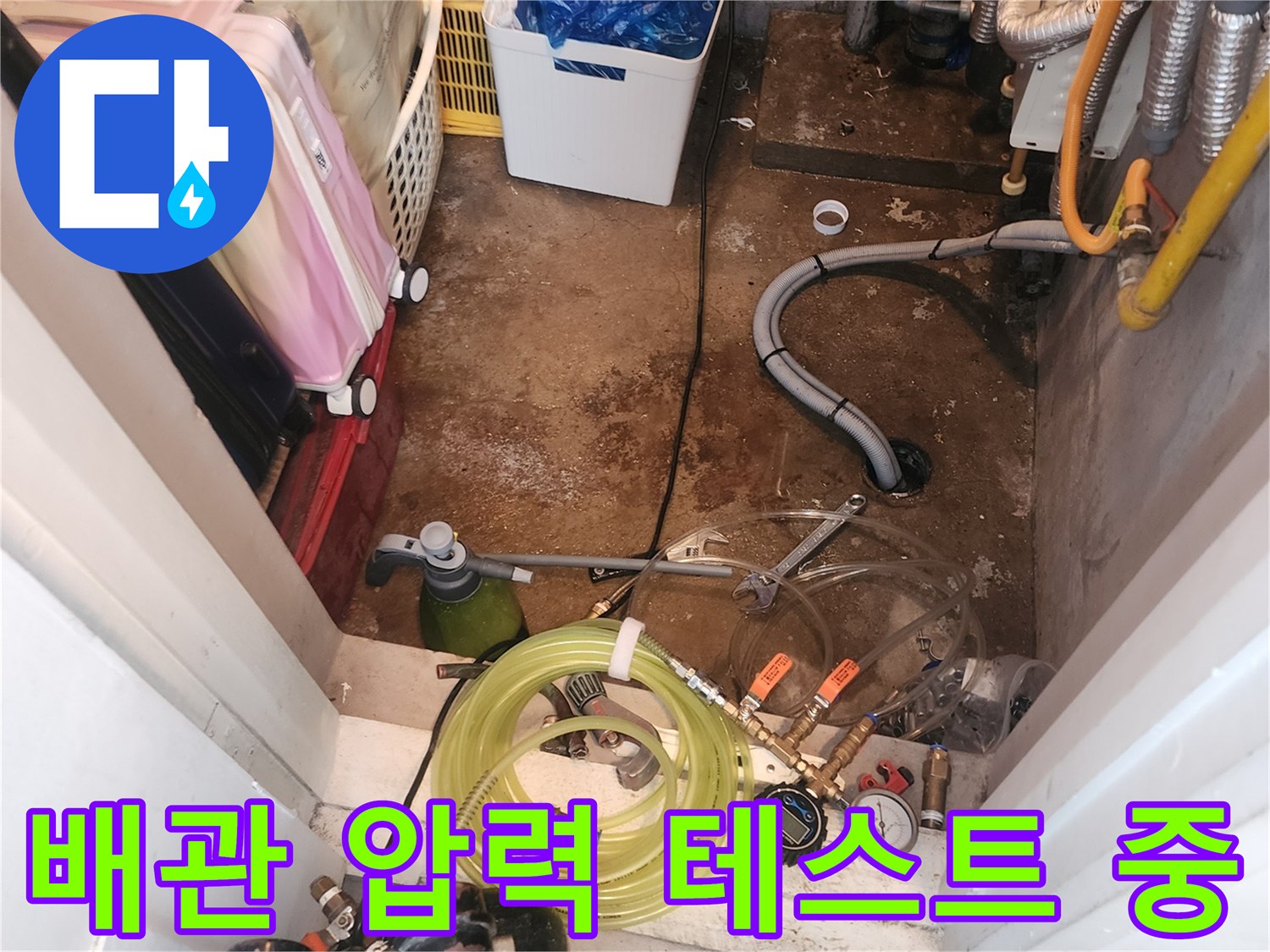 숫자가 표시된 압력계와 노란색 호스가 연결된 배관 검사 장면