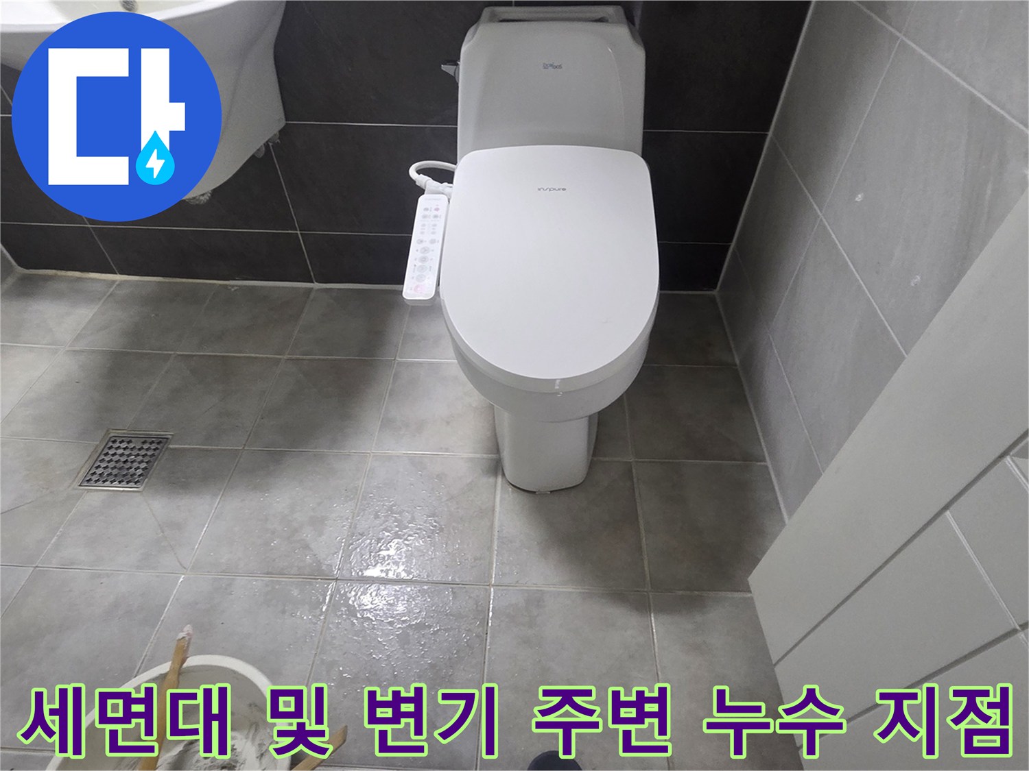 욕실 바닥의 배수구와 변기 하단부 틈새를 클로습하게 촬영한 사진입니다.