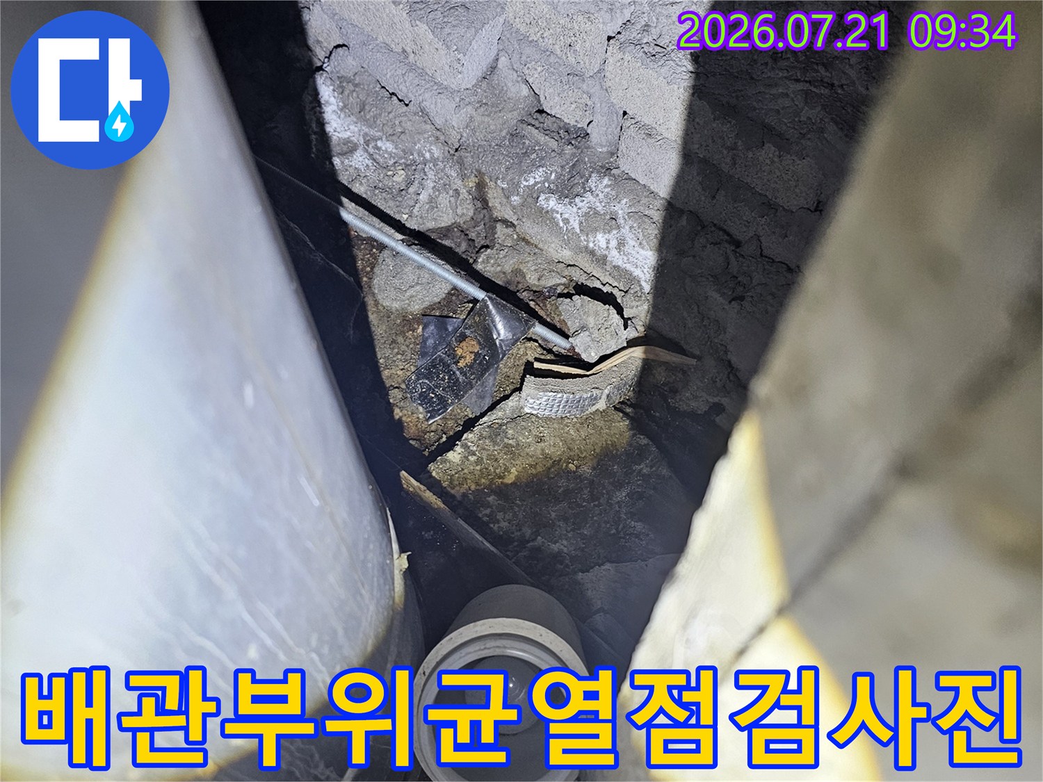 상부 배관과 콘크리트 슬래브 사이의 균열 지점 점검 장면