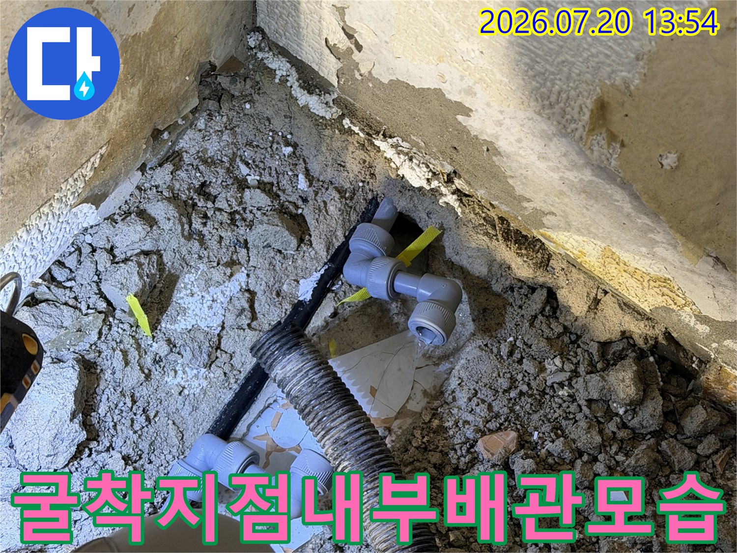 파란색 플라스틱 배관과 L자형 엘보우-연결관이 노출된 모습