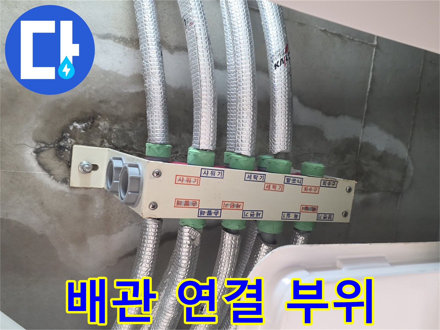 은색 보온재가 씌워진 다수의 배관이 모여 있는 천장 내부 구조