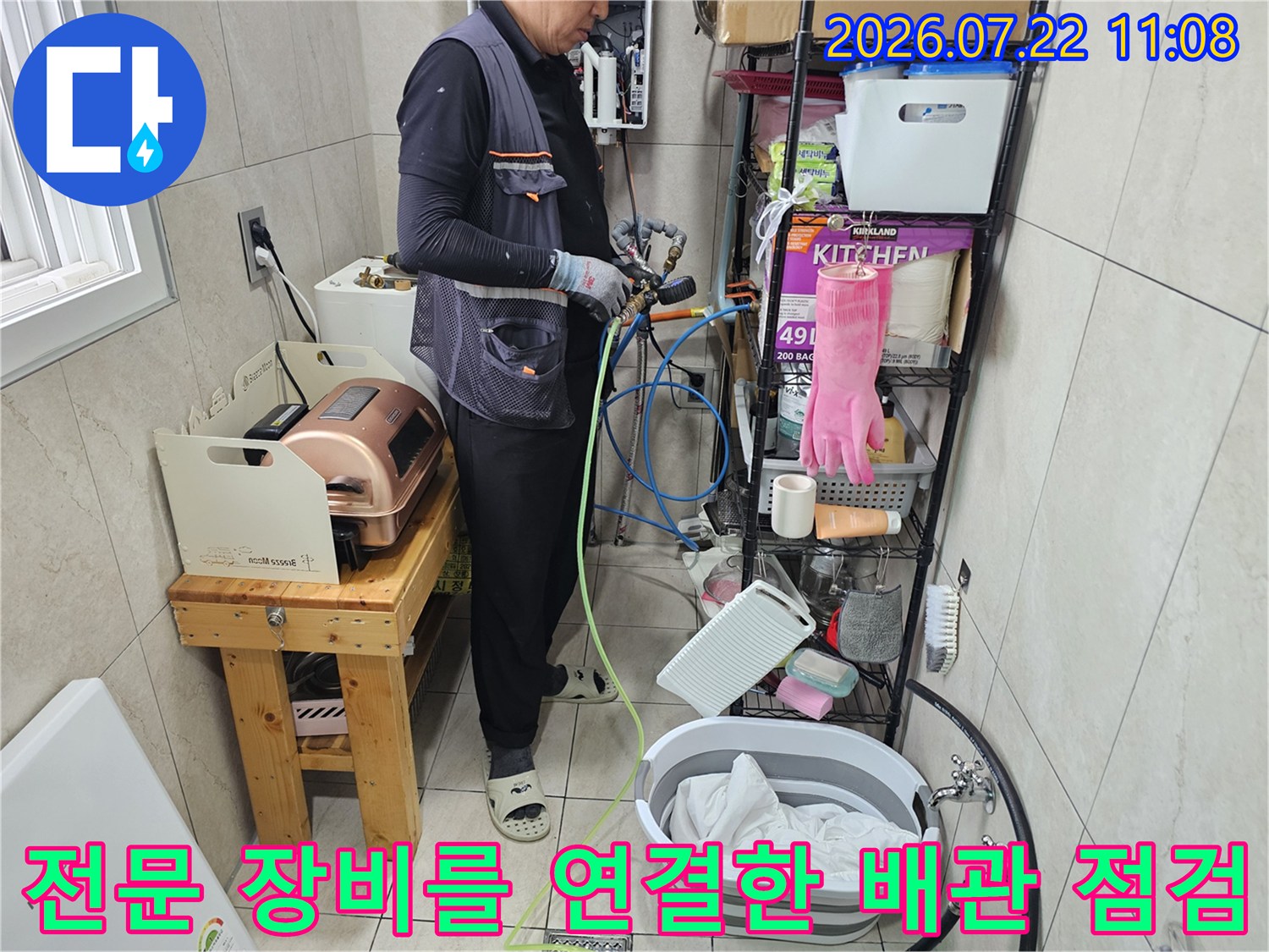 파란색과 노란색 호스를 이용해 배관의 기밀성을 테스트하고 있는 엔지니어의 모습