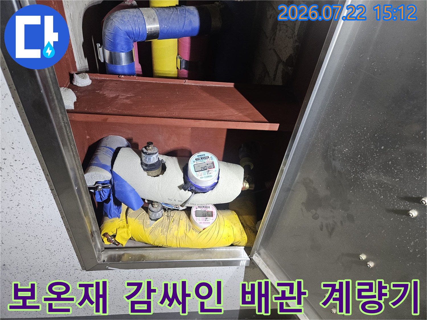 배관 보호용 보온재 위에 설치된 디지털 수도 계량기의 근접 사진