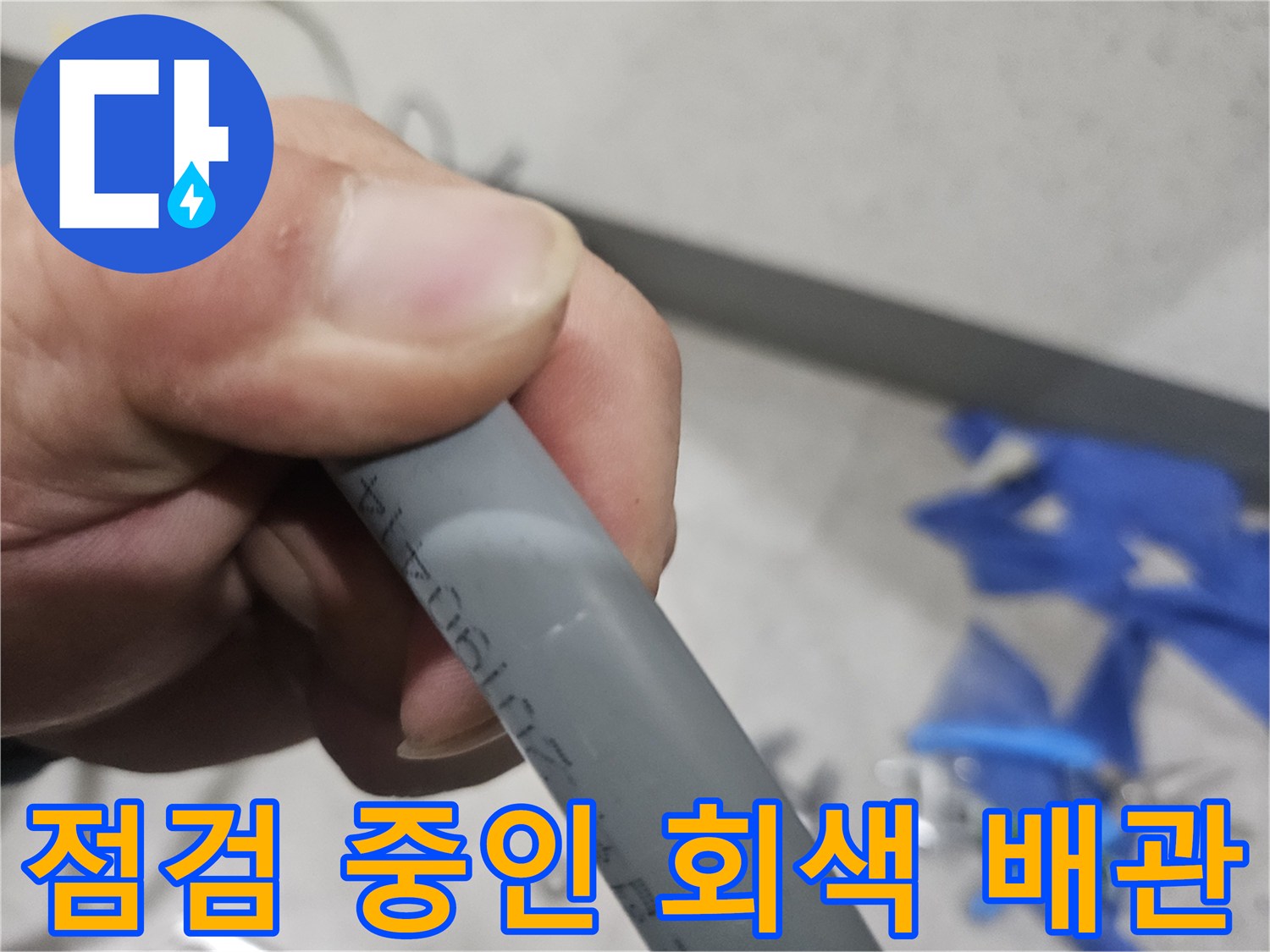 배관의 상태를 확인하기 위해 손으로 잡고 있는 모습-누수 진단