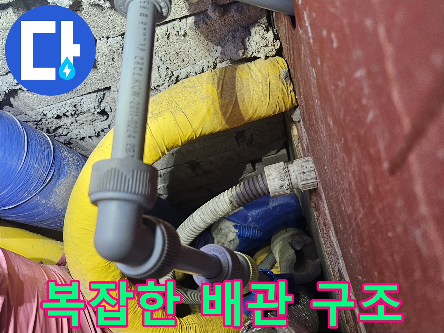 보온재와 파이프가 얽혀 있는 천장 내부 배관 모습입니다.
