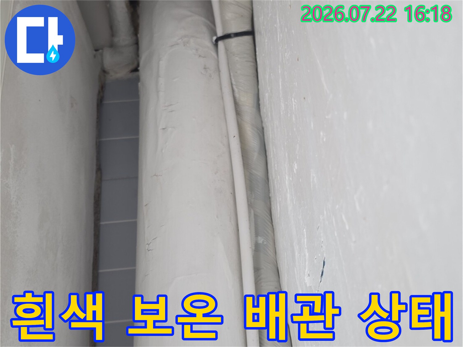보온재가 씌워진 두꺼운 흰색 배관이 수평으로 배치된 모습-누수 진단 과정