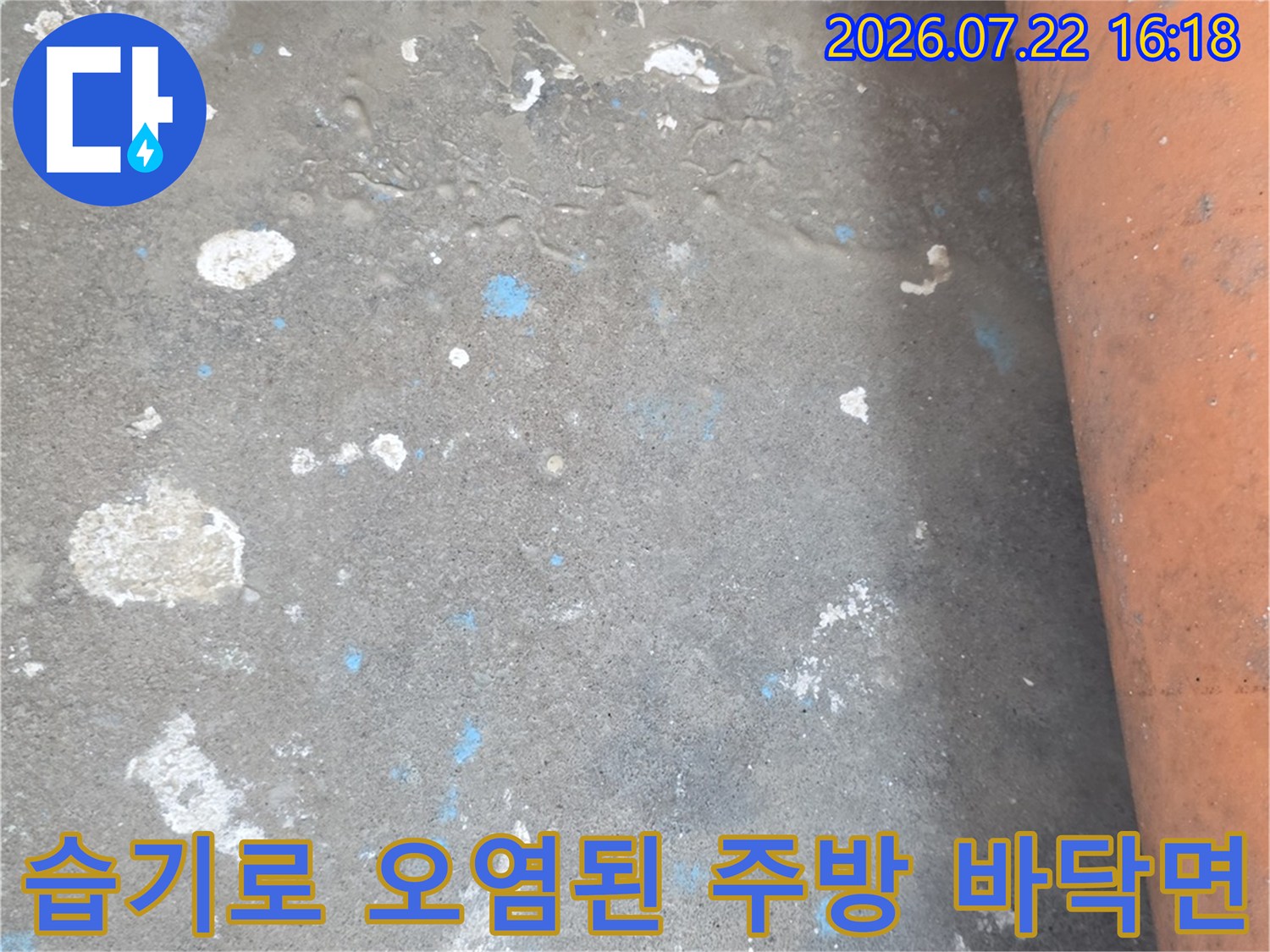 시멘트-바닥에-물자국과-흰색-얼룩이-남아있고-상단에-분홍색-배관이-설치된-현장-사진