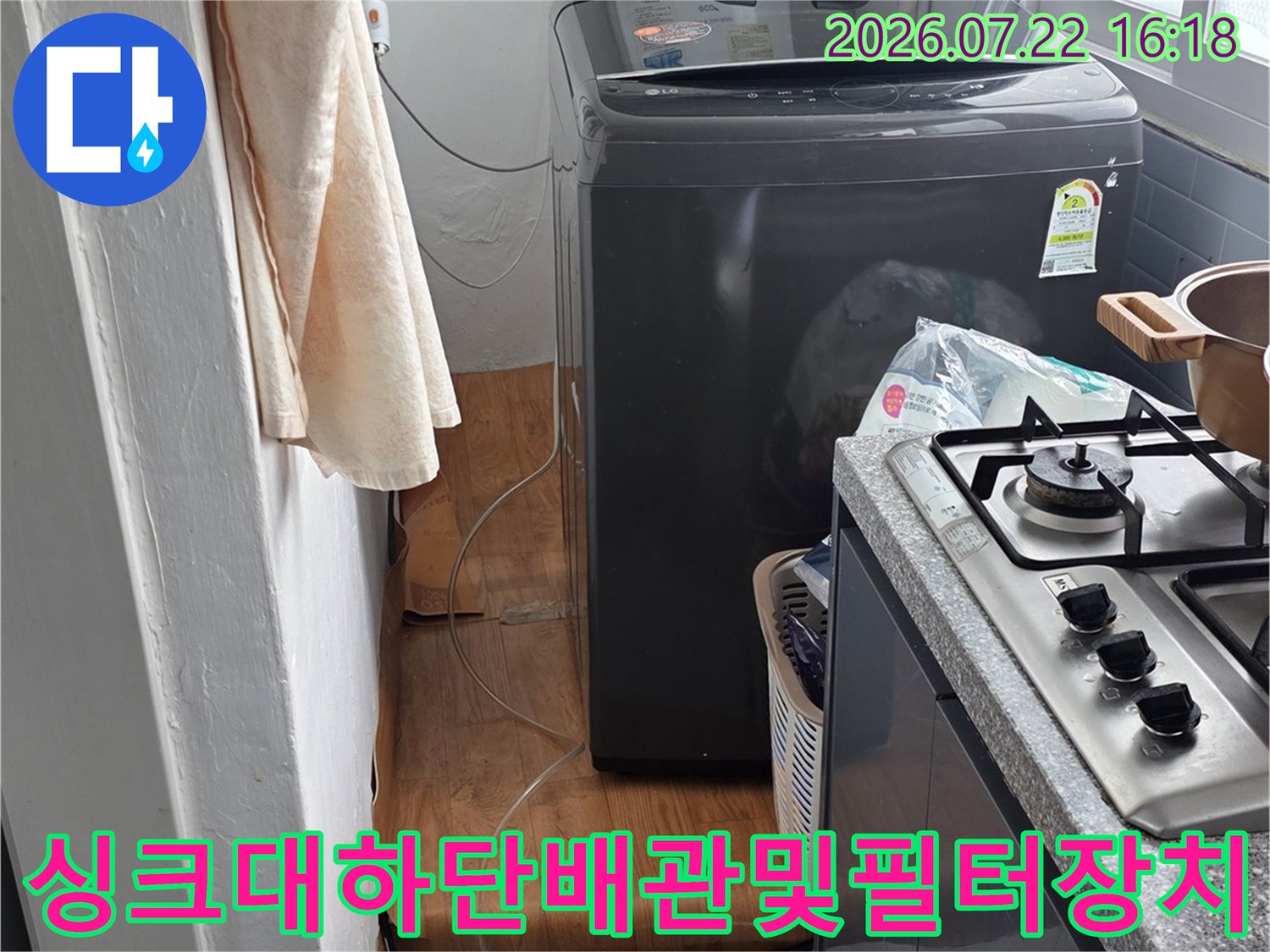 주방 가구 하부에 설치된-정수기 필터 시스템과 배관 연결부 모습