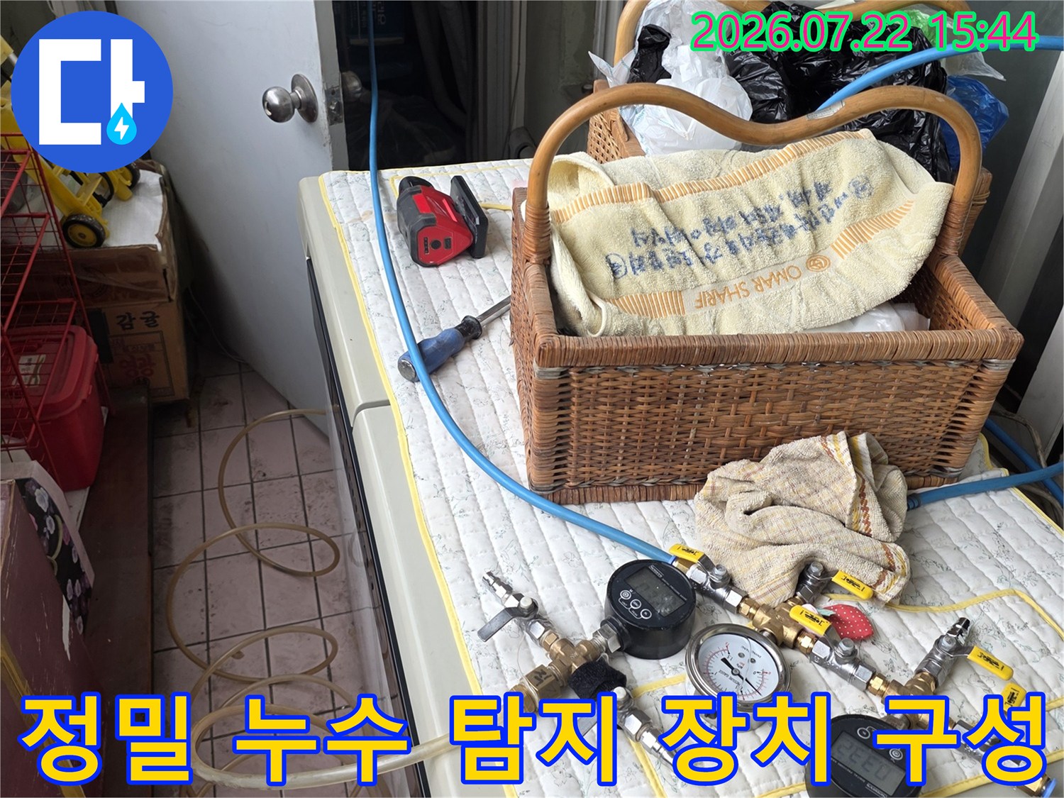 누수 검사용 압력 게이지와 파란색 연결 호스가 놓여 있는 작업대 모습