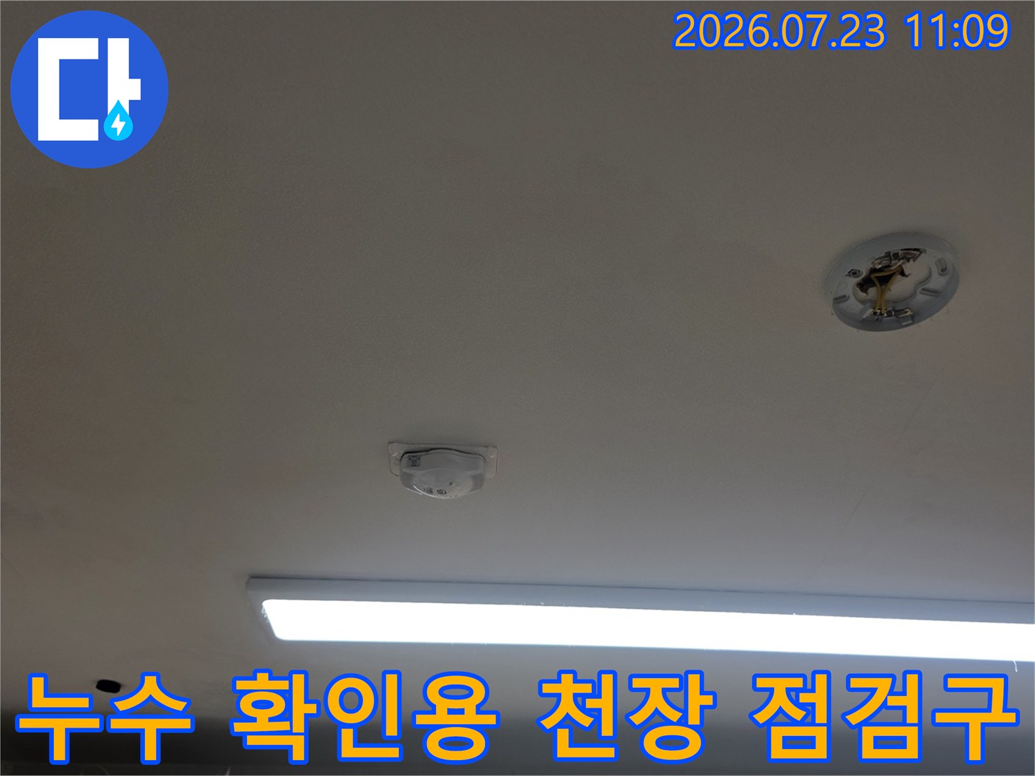 매립형 조명 옆에 위치한 원형 천장 점검구와 화재감지기-누수 진단 부위