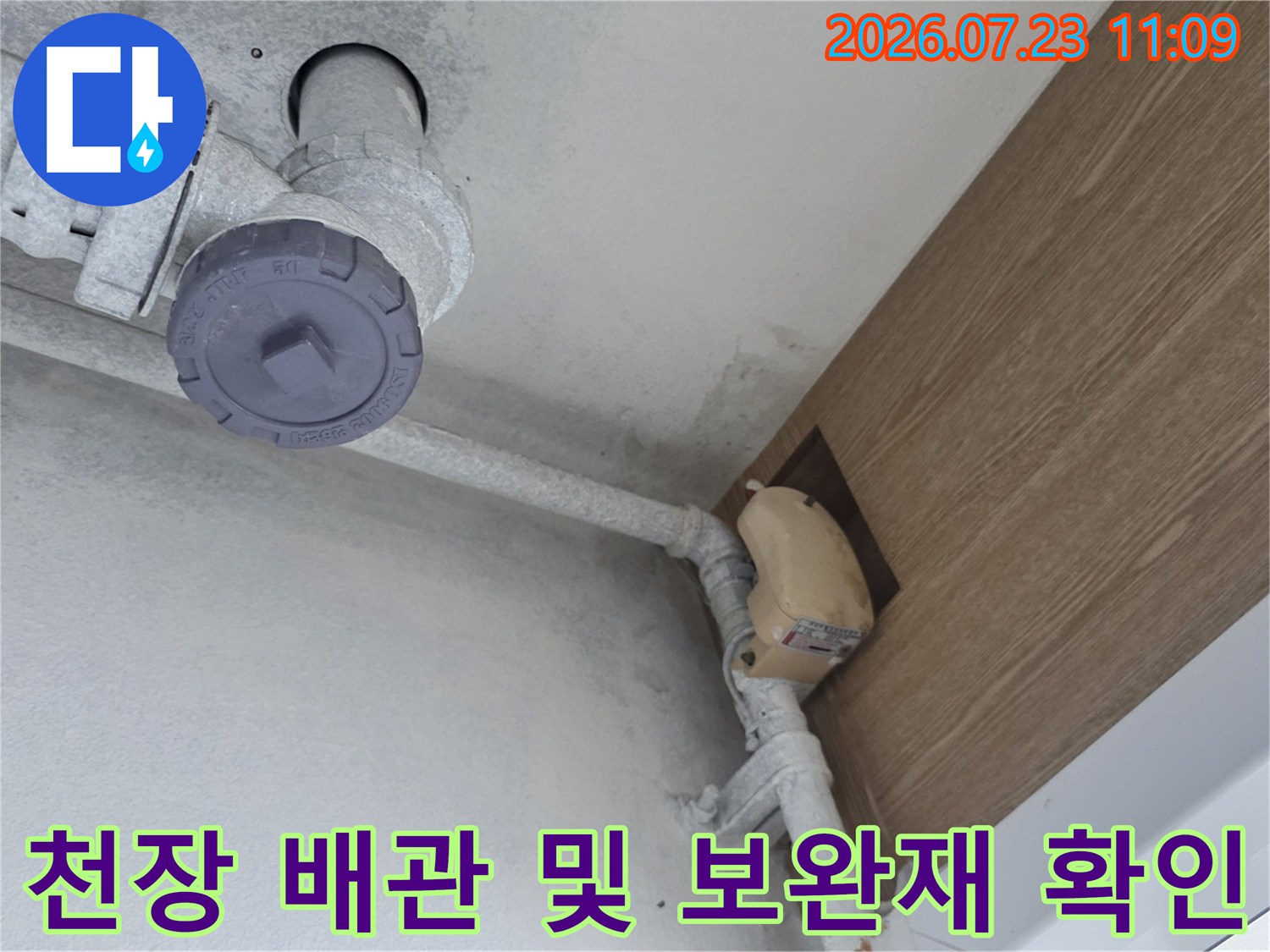 아파트-천장의-흰색-배관과-연결부위에-부착된-보완-자재-모습