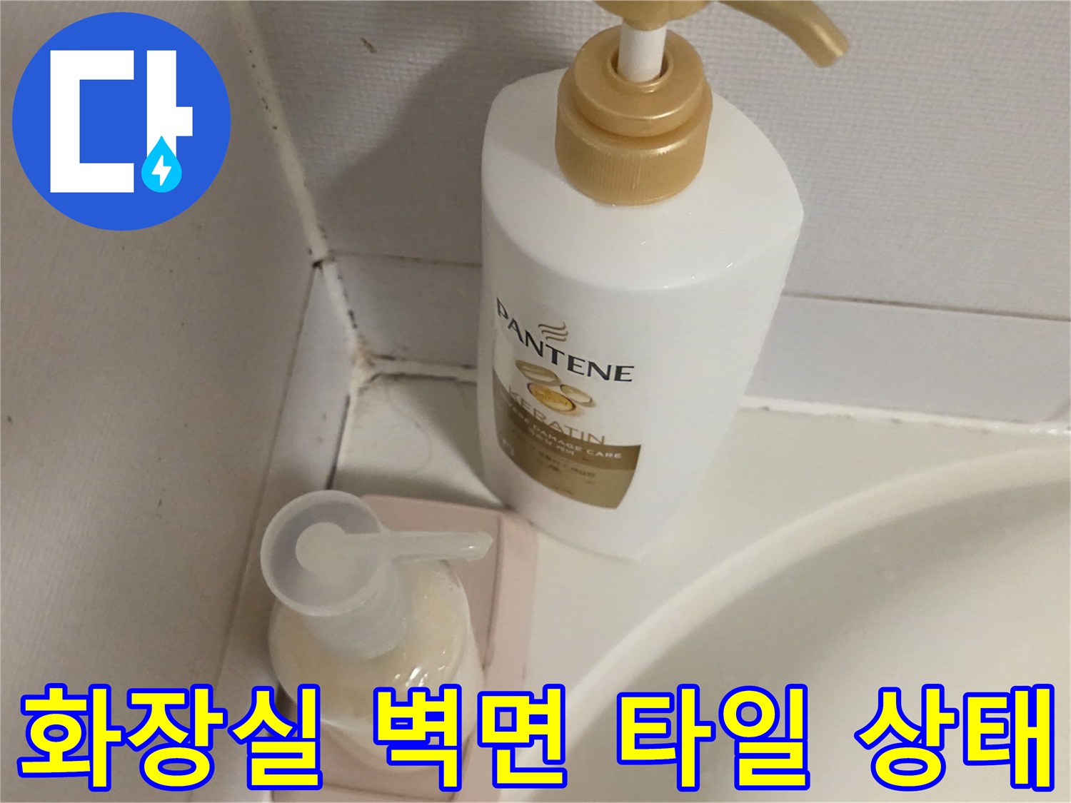 욕실 세면용품 뒤쪽의 타일 벽면과 하단부 모습