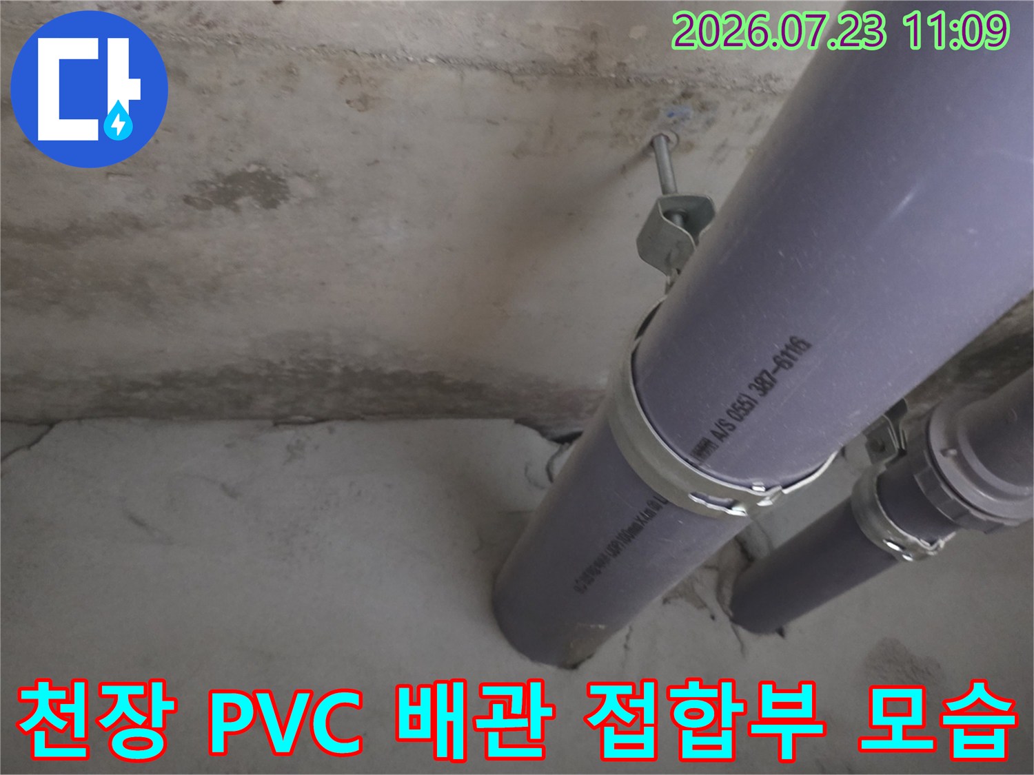 콘크리트 천장에 설치된 회색-PVC배수관과 금속 고정 밴드 사진