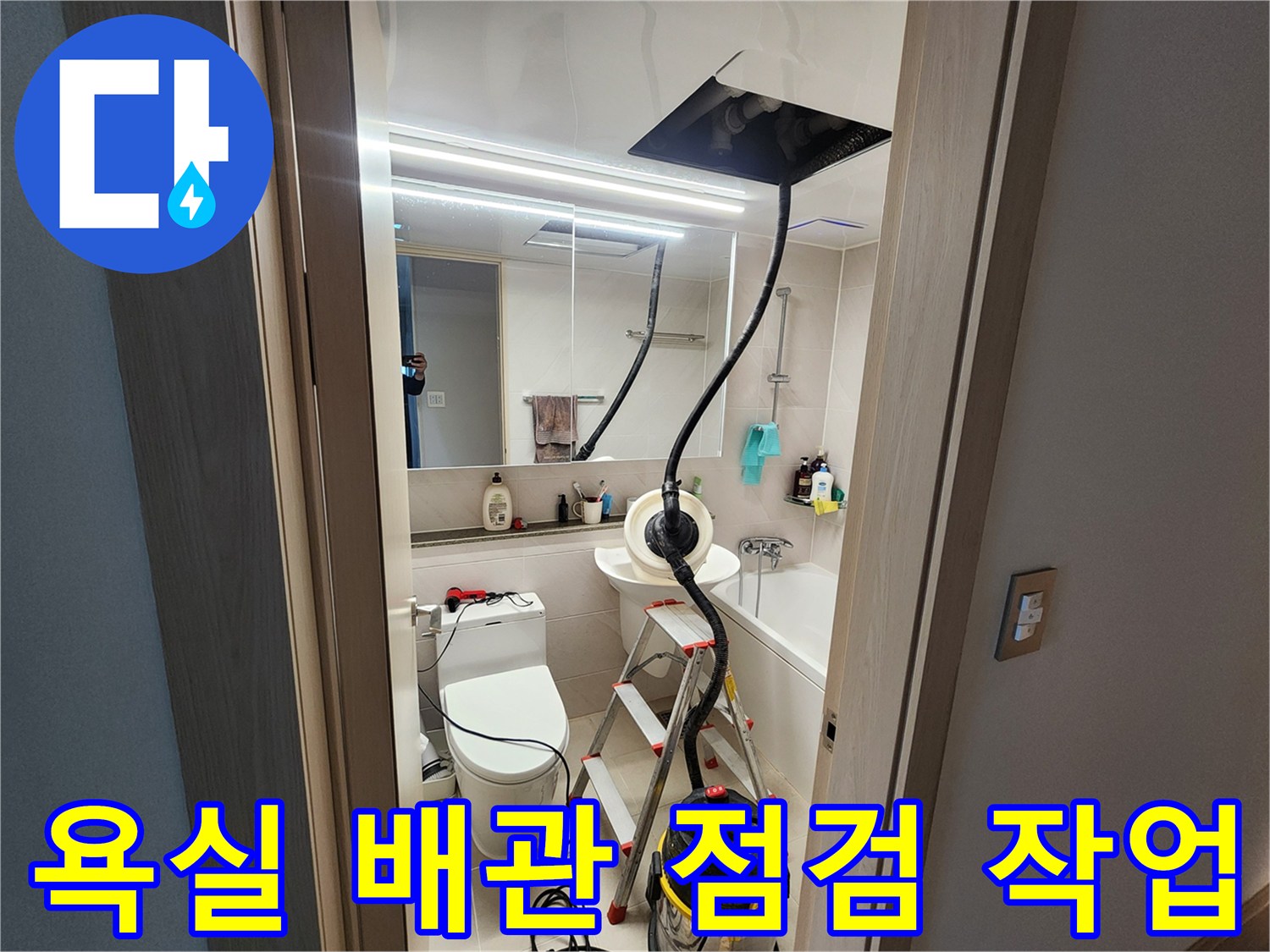 화장실 바닥에 놓인 산업용 청소기와 사다리를 이용한 내부 점검 상황