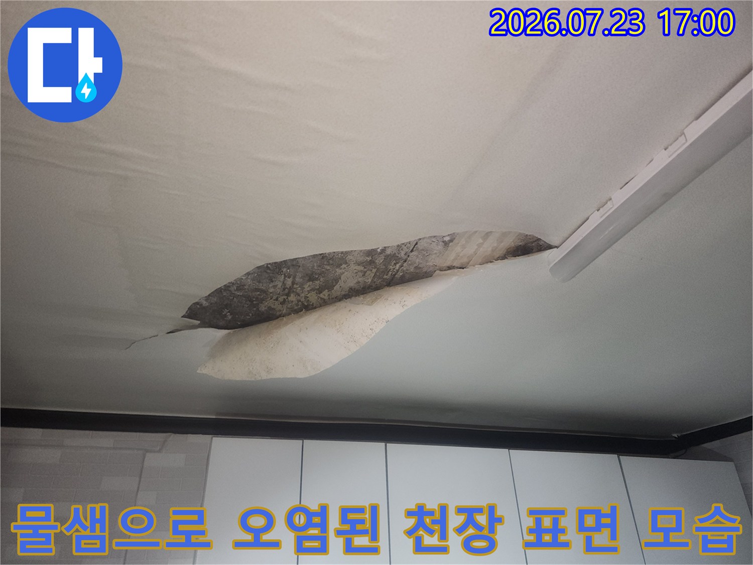 누수로 인해 변색되고 마감재가 일부 탈락한 거실 천장의 상세 사진