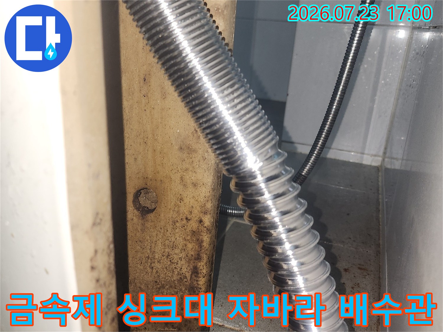 싱크대 하부에 설치된-은색의 주름진 형태 배수 호스
