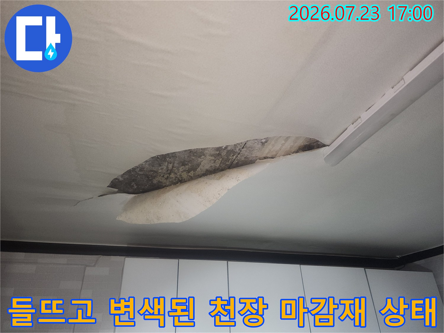 천장 마감재가 누수로 인해 젖어 색이 변하고 일부가 아래로 처진 모습