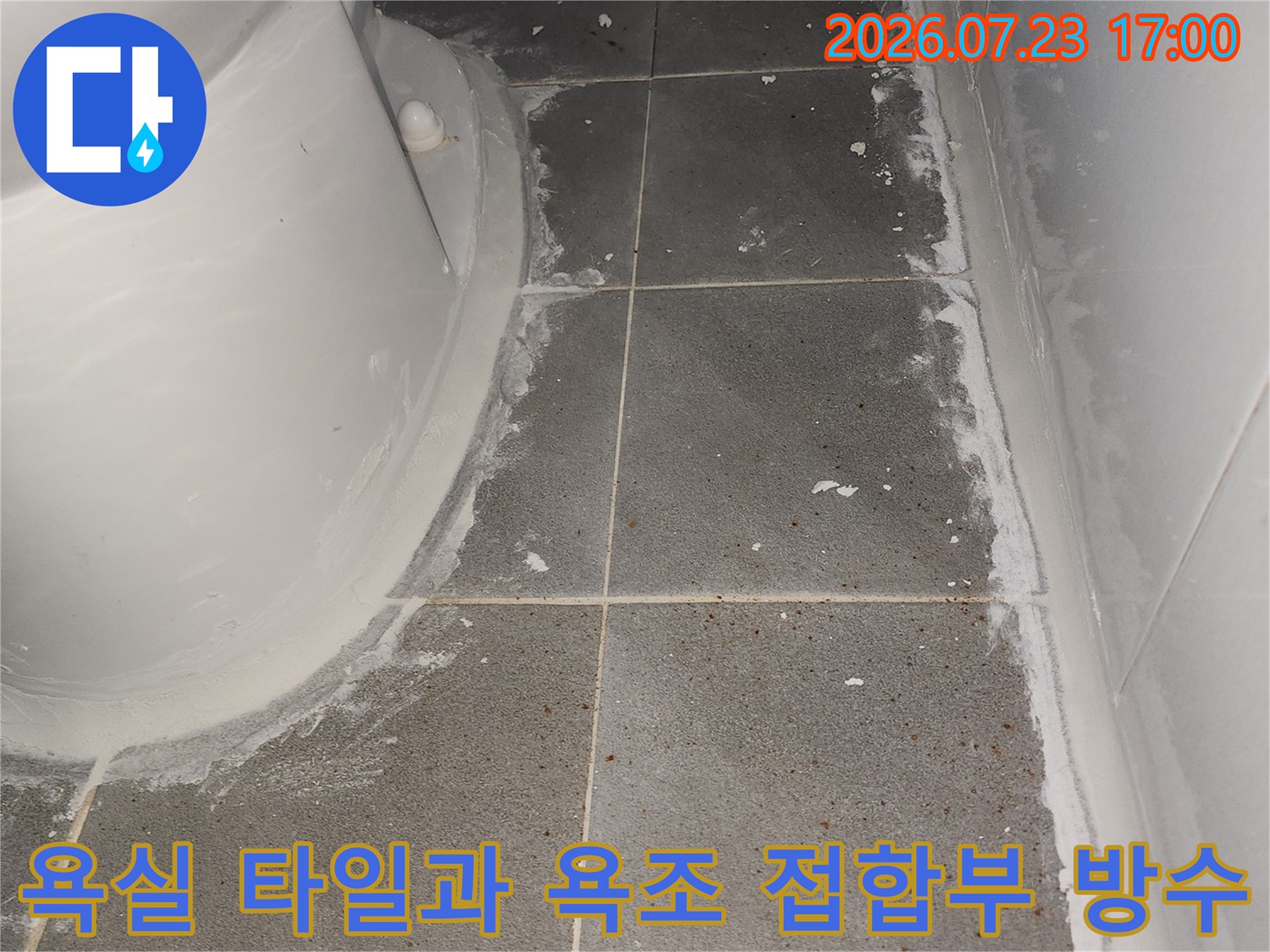 회색 타일 벽면과 흰색 욕조 경계선에 방수용 실리콘이 시공된 상태