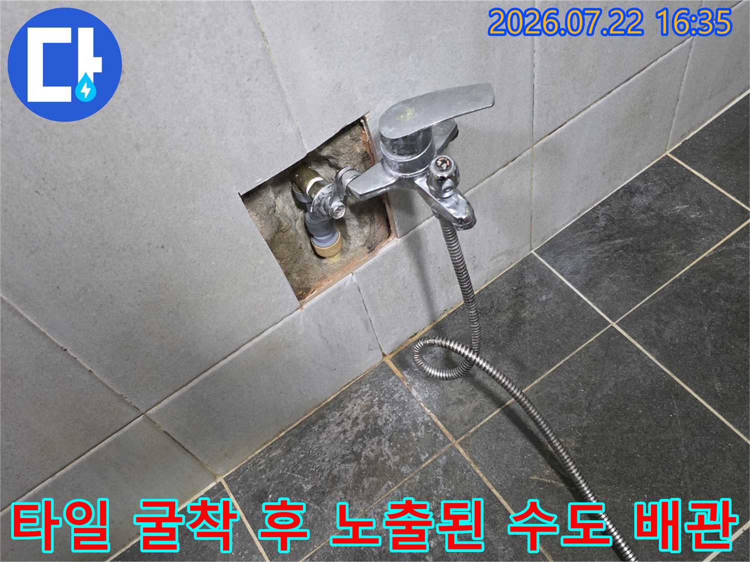 벽면 타일을 일부 제거하여 드러난 수도꼭지-매립 배관 연결부의 모습