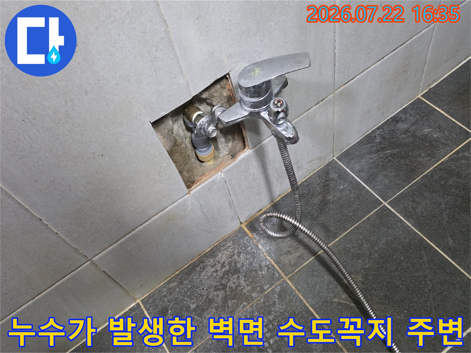 벽면에 고정된 금속 재질의 수도꼭지와 누수를 확인하기 위해 굴착된 타일 주변부