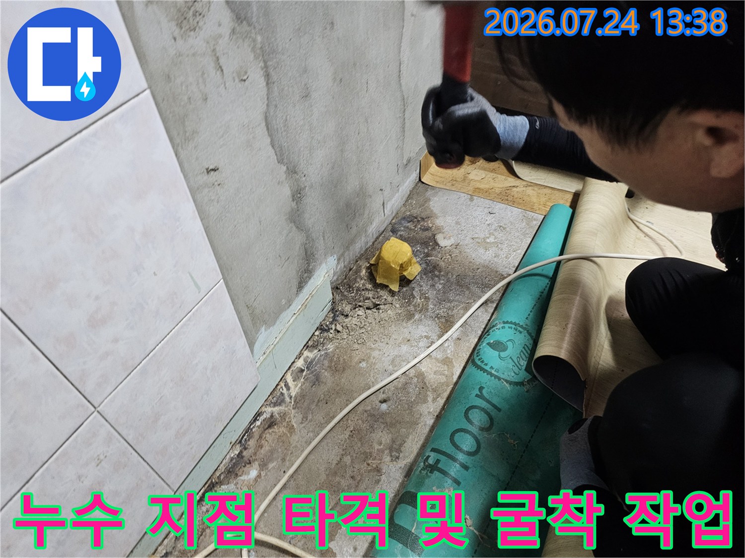 검은색 장갑을 낀 작업자가 도구를 사용하여 바닥 콘크리트를 제거하는 장면