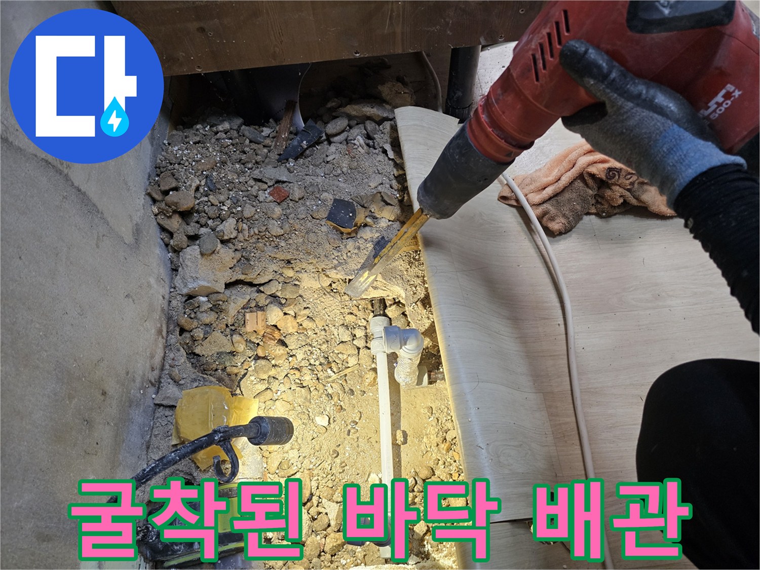 싱크대 아래 굴착 부위-노출된 수도 배관과 주변 자재들
