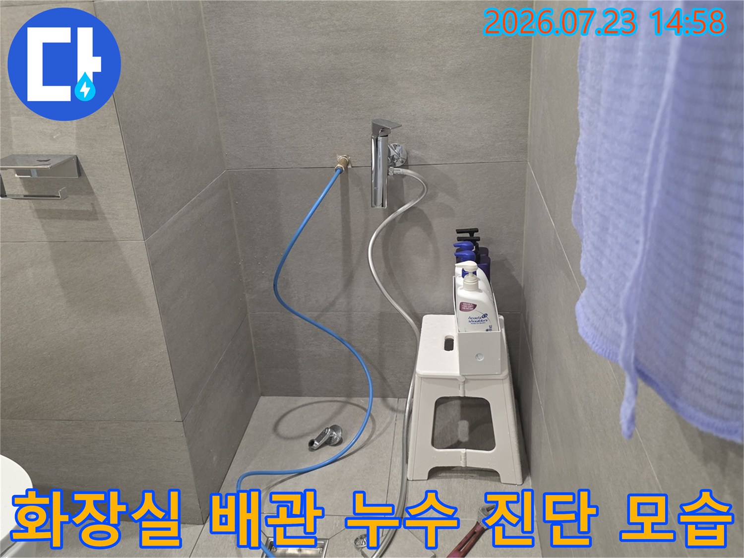 화장실 벽면 수도꼭지와 연결된 파란색 호스-누수 탐지 장비 설치 모습