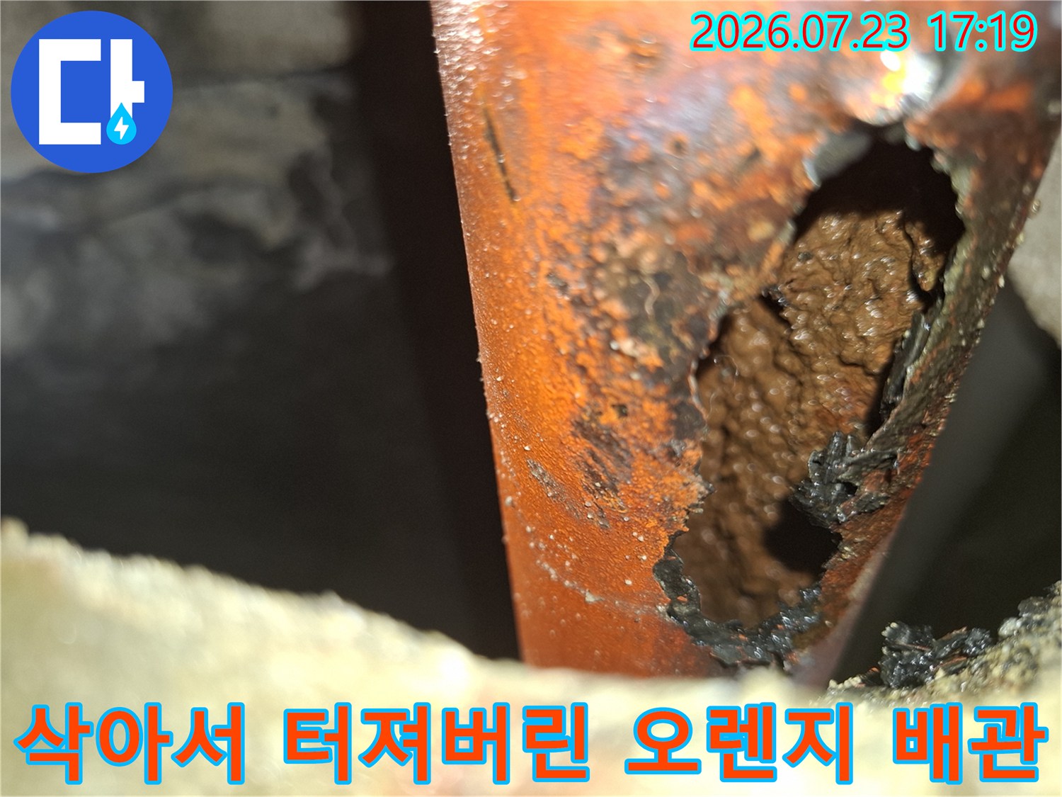 심한 부식으로 인해 외벽이 손실되어 구멍이 난 주황색 배관 모습