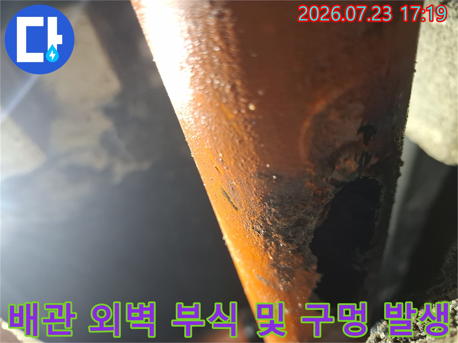 심한 부식으로 인해 표면이 뜯겨 나가고 커다란 구멍이 형성된 주황색 배관 사진