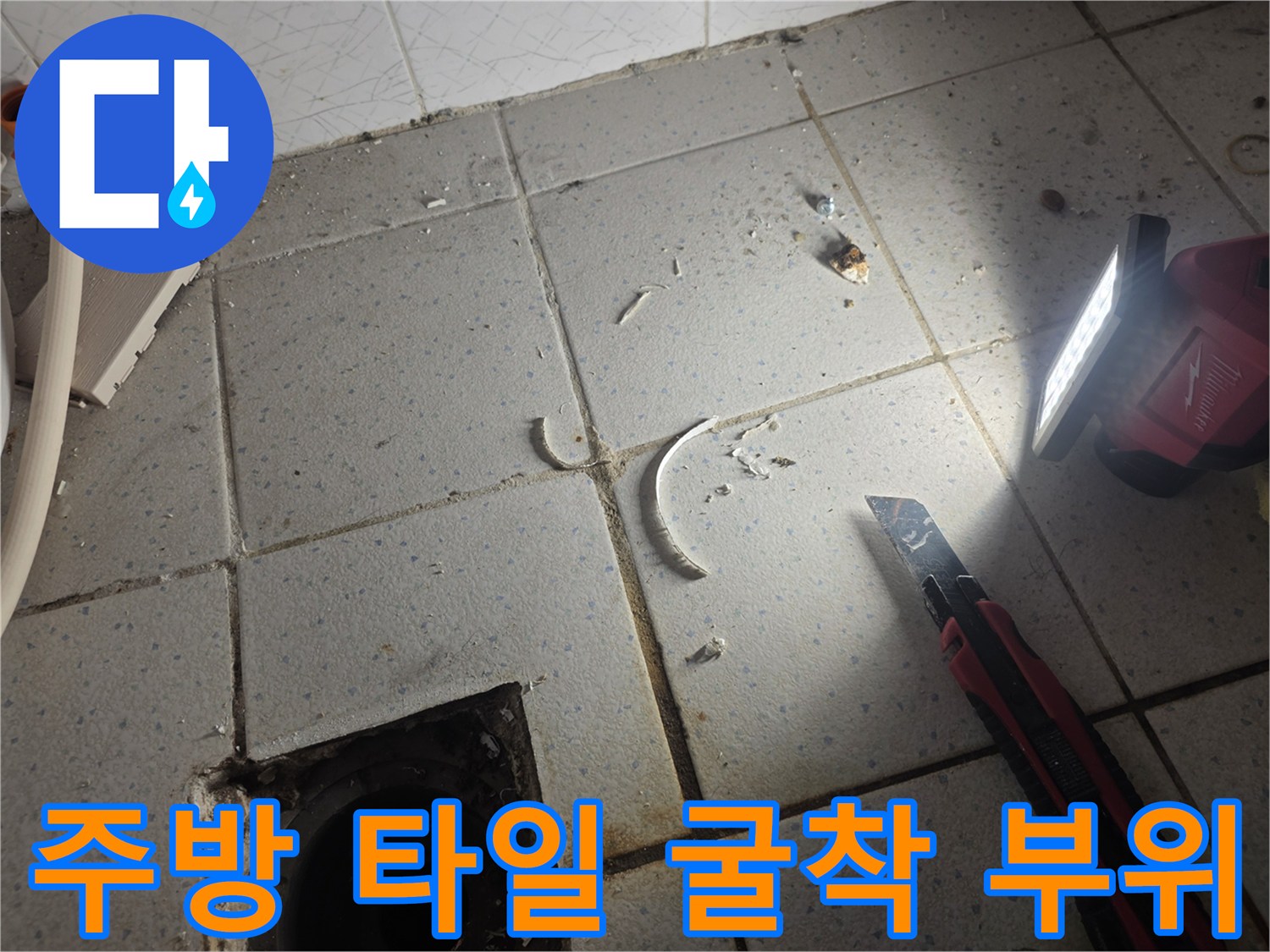 타일 아래 배수관 주변의 누수 흔적을 찾기 위한 작업 현장