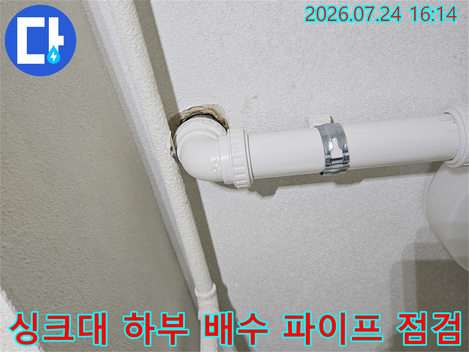 싱크대 아래 설치된 흰색 PVC 배수관과 연결 부위의 모습