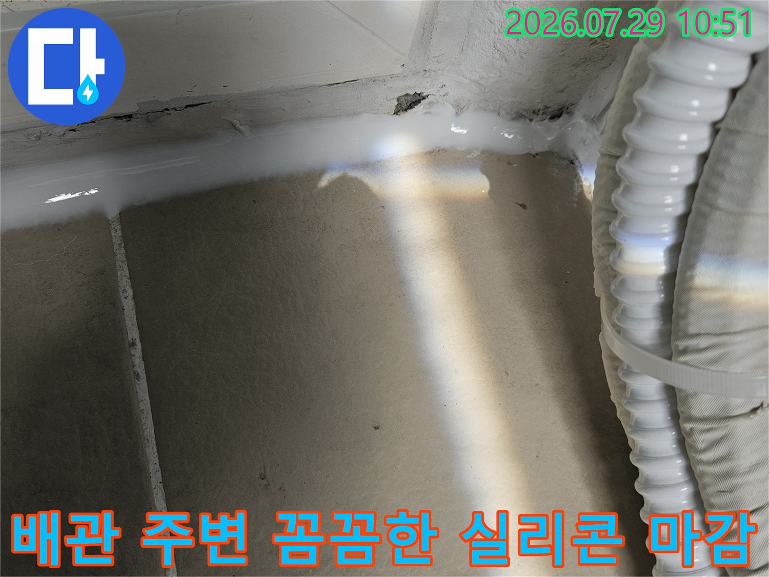 배관과 벽면의 경계 부위를 실리콘으로 밀실하게 채운 장면