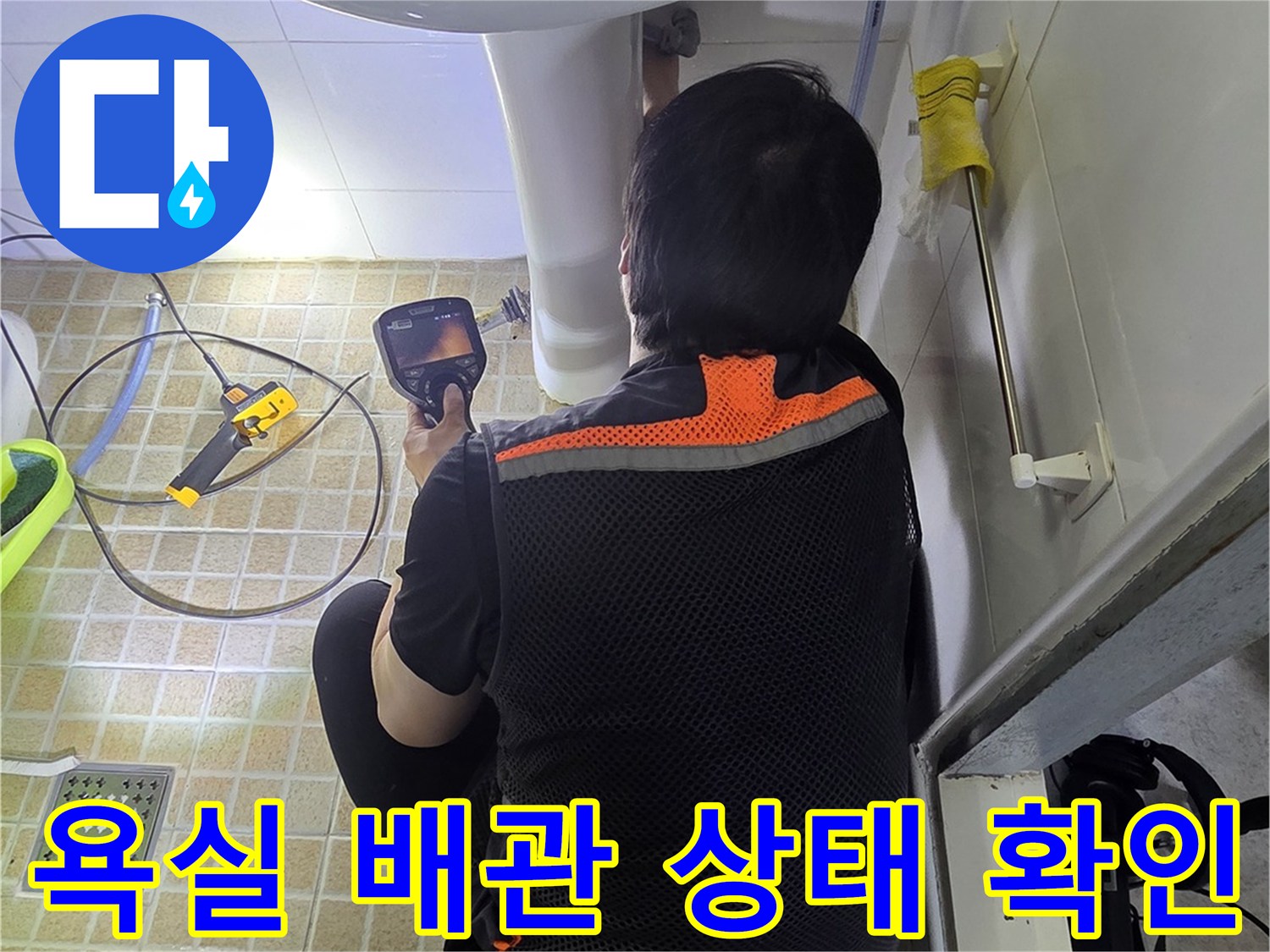 세면대-하단부-배관-주변을-조명으로-비추어-살피는-모습