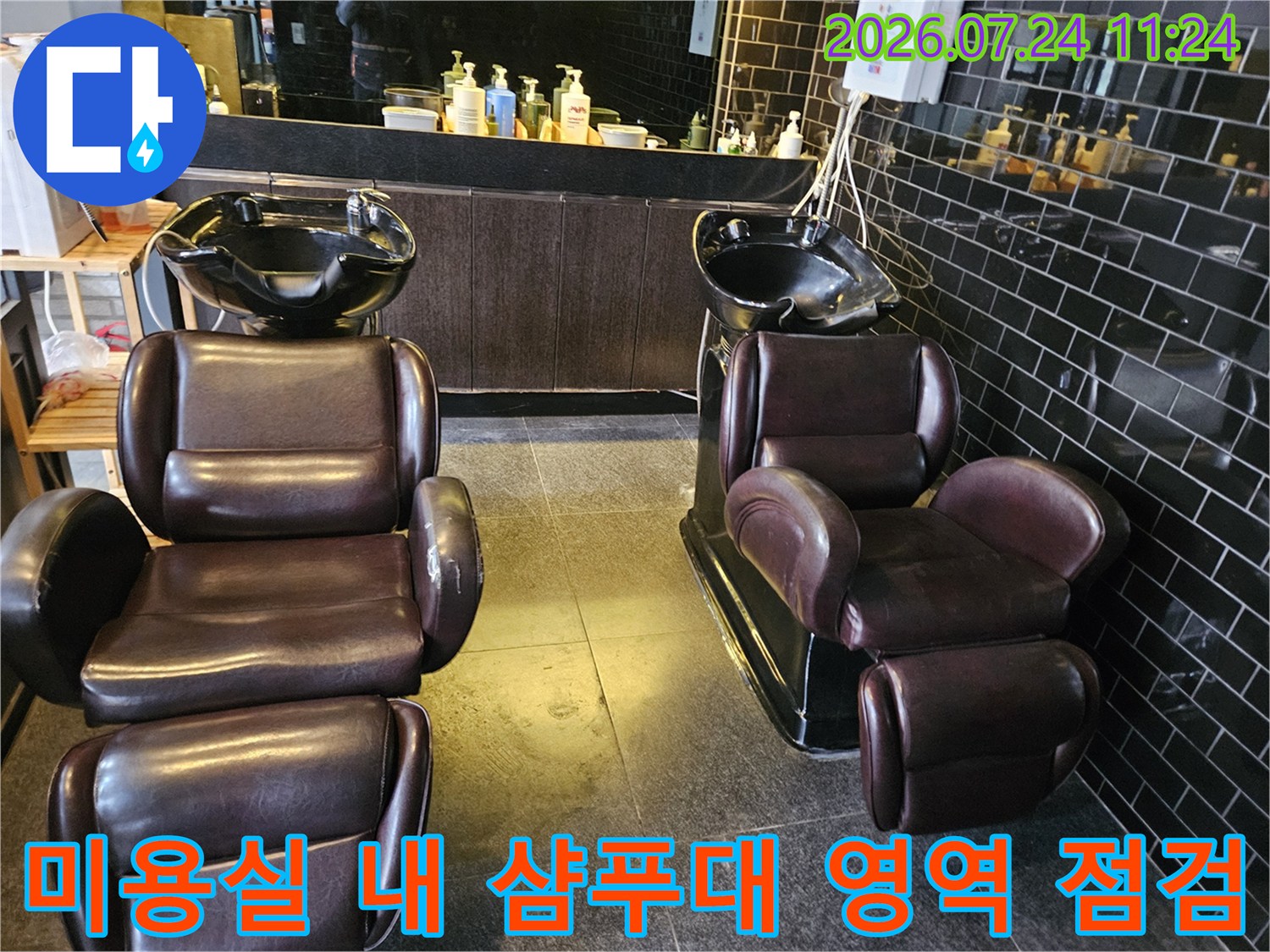 갈색 가죽 소재의 샴푸대가 배치된 매장 내부 공간