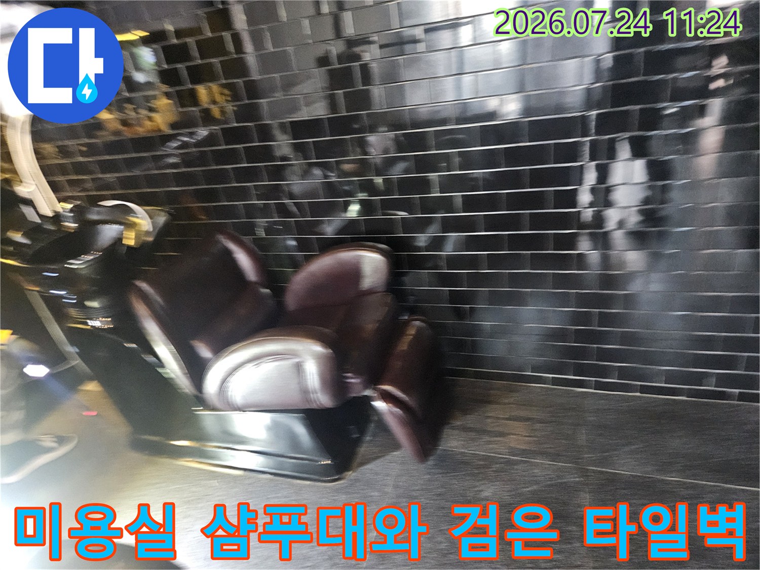 미용실 내부에 설치된 샴들대와 세련된 검은색 타일 벽면