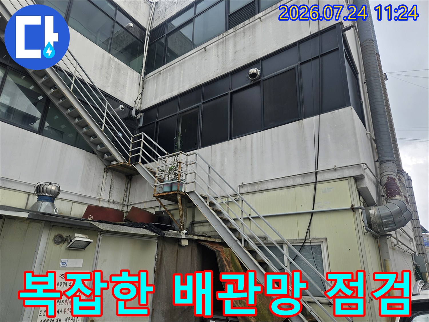 상업용 건물의 외벽과 연결된 복합적인 배관 시스템 진단 모습