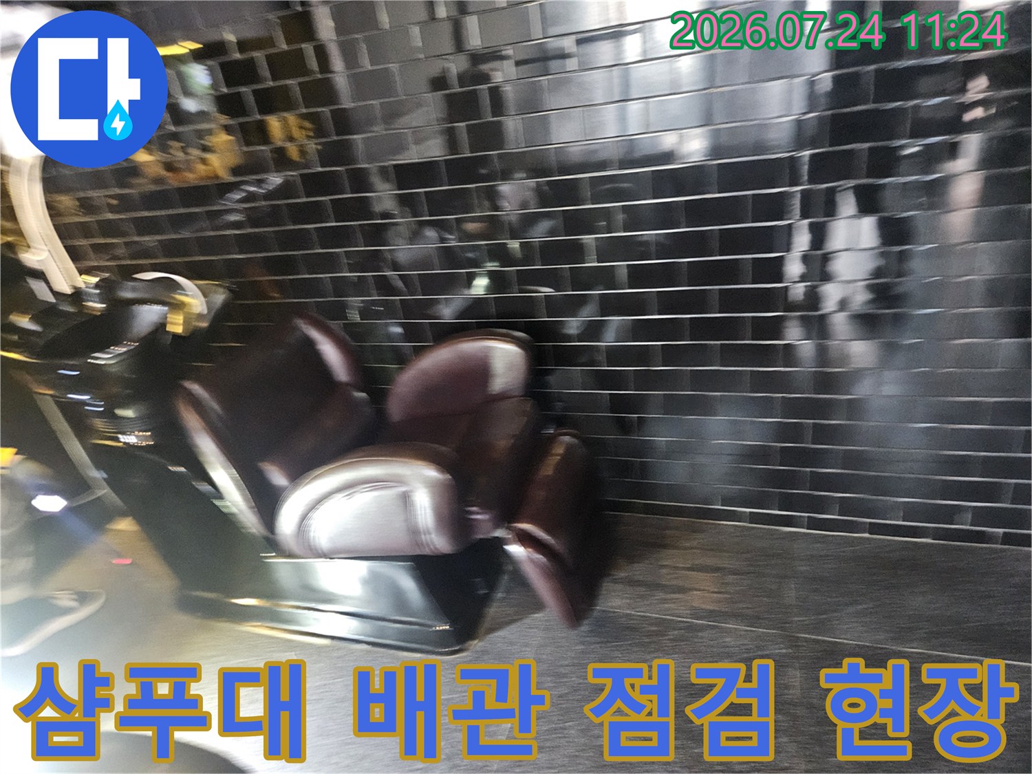어두운 톤의 타일 벽면과 설치된 미용실용 샴푸대