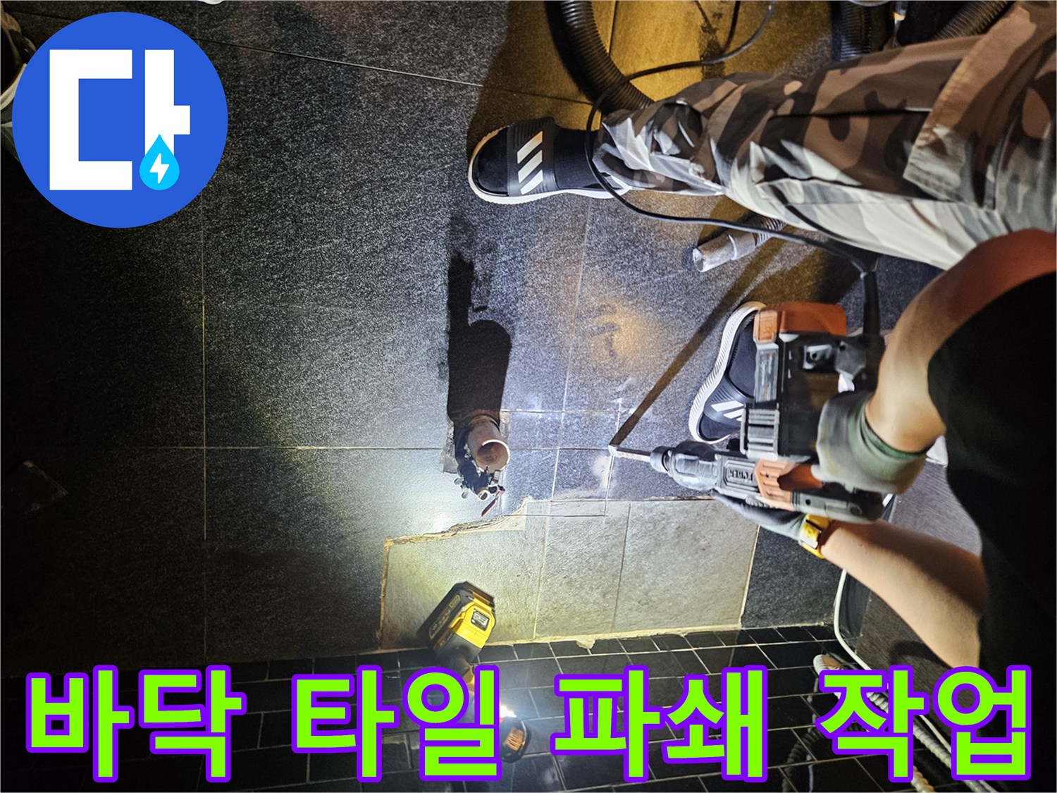 전동 절단기를 사용하여 누수 의심 지점의 타일을 분리하는 모습입니다.