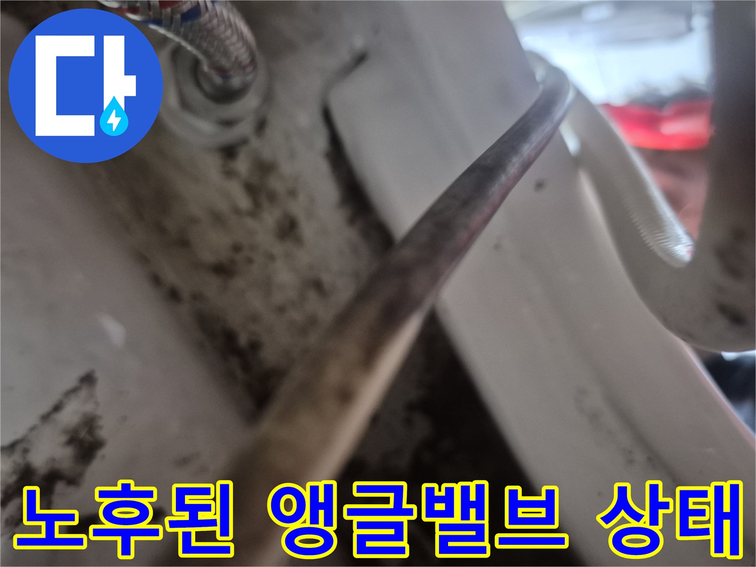 변기 앵글밸브와 급수 호스의 연결 부위를 근접 촬영한 사진입니다.