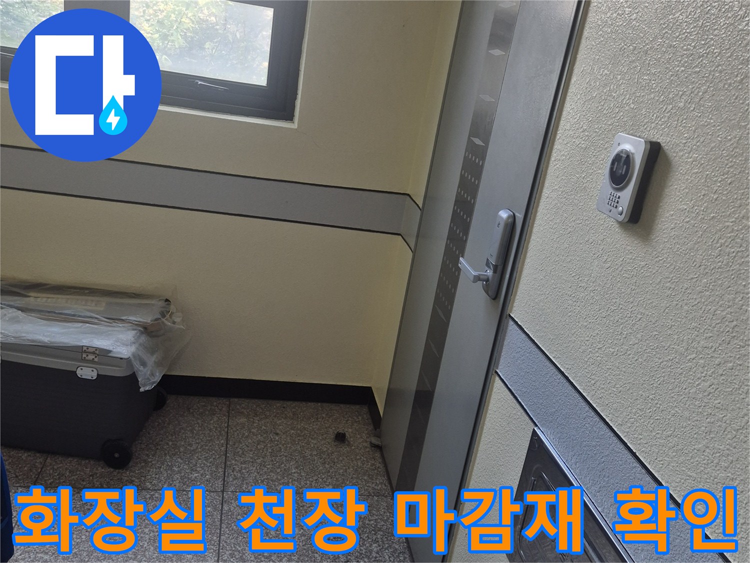 욕실 천장의 점검용 덮개와 바닥에 놓인 작업용 배낭