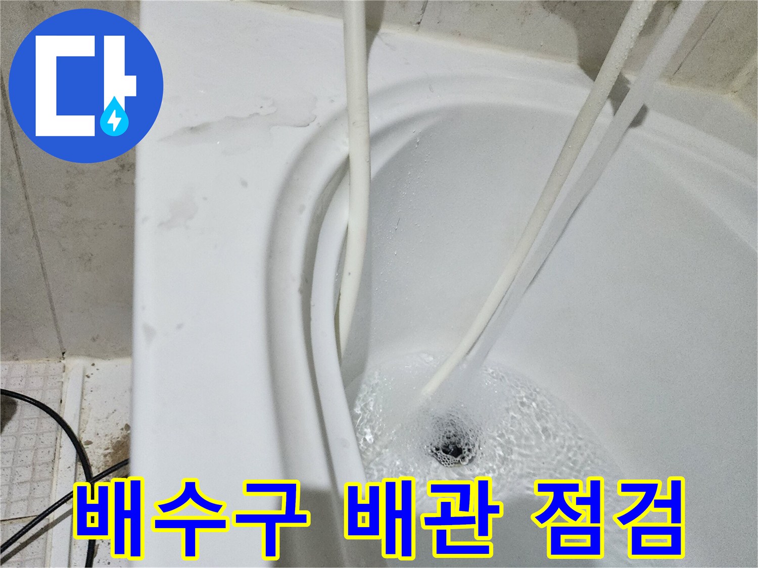 하얀색 배수구로 흰색 관이 들어가는 모습-누수 진단 중