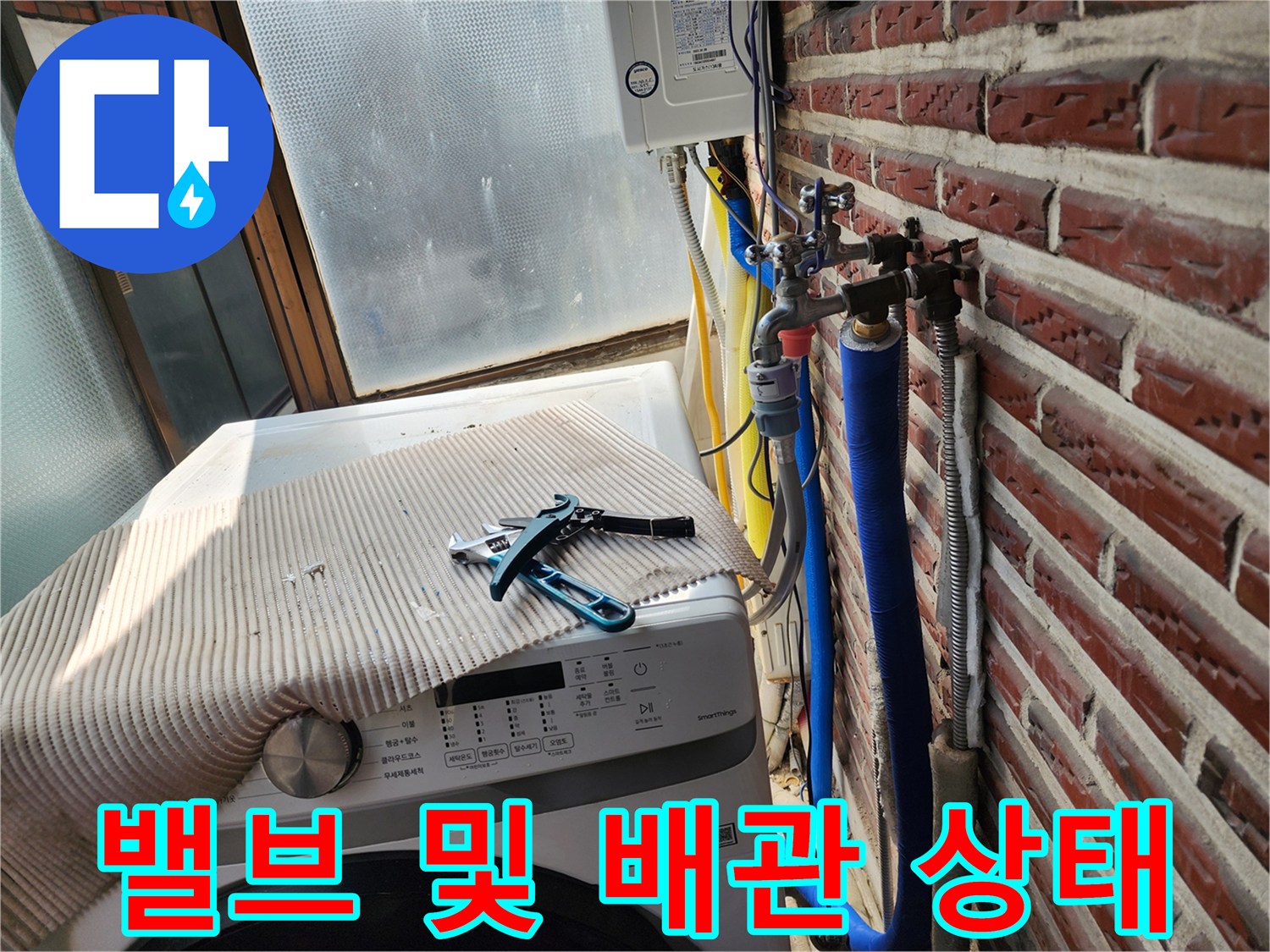 벽돌 벽면의 파란색 보온재 배관과 금속 밸브 부위