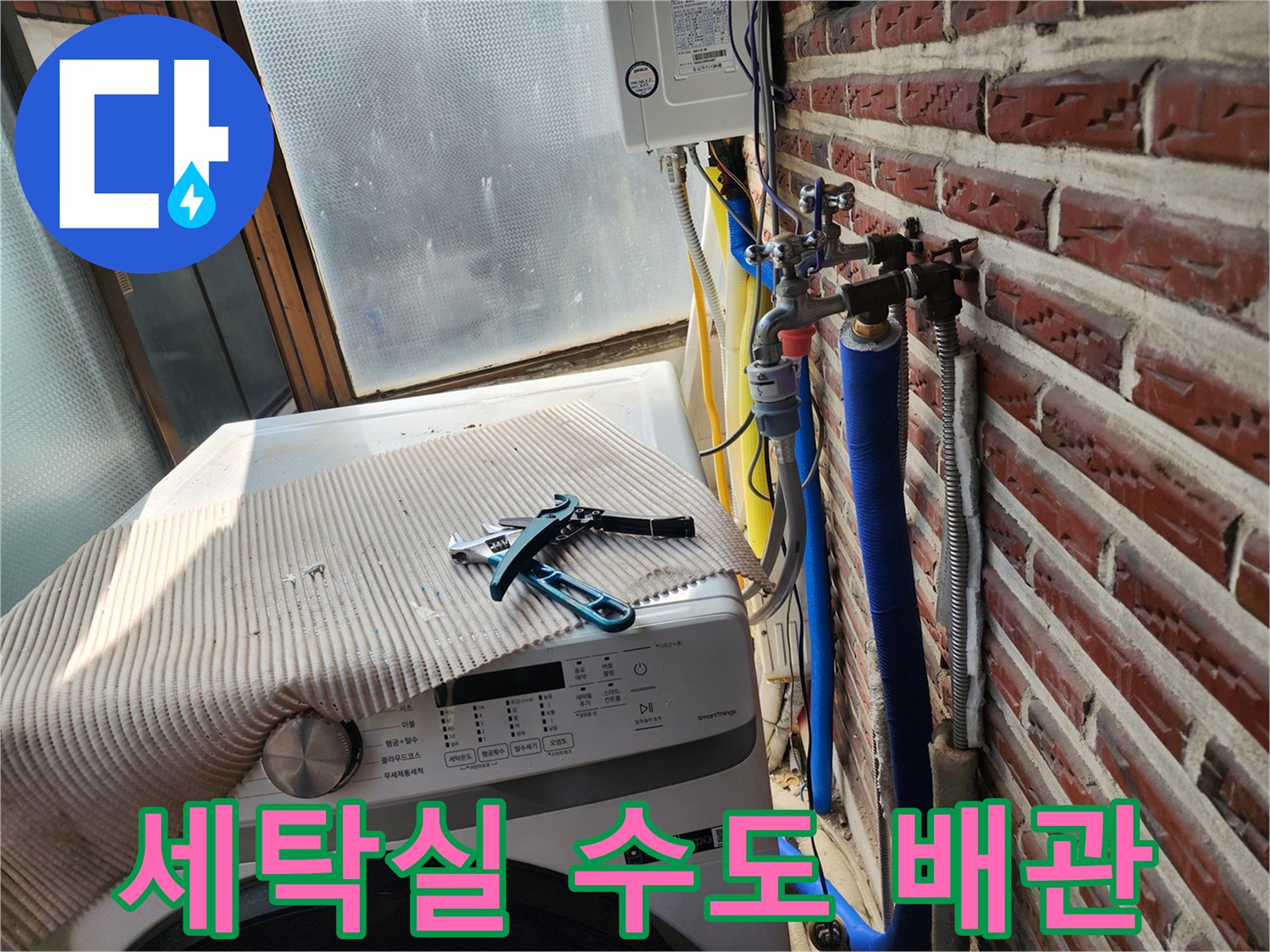세탁기 근처의 작업 도구와 벽면 노출 배관