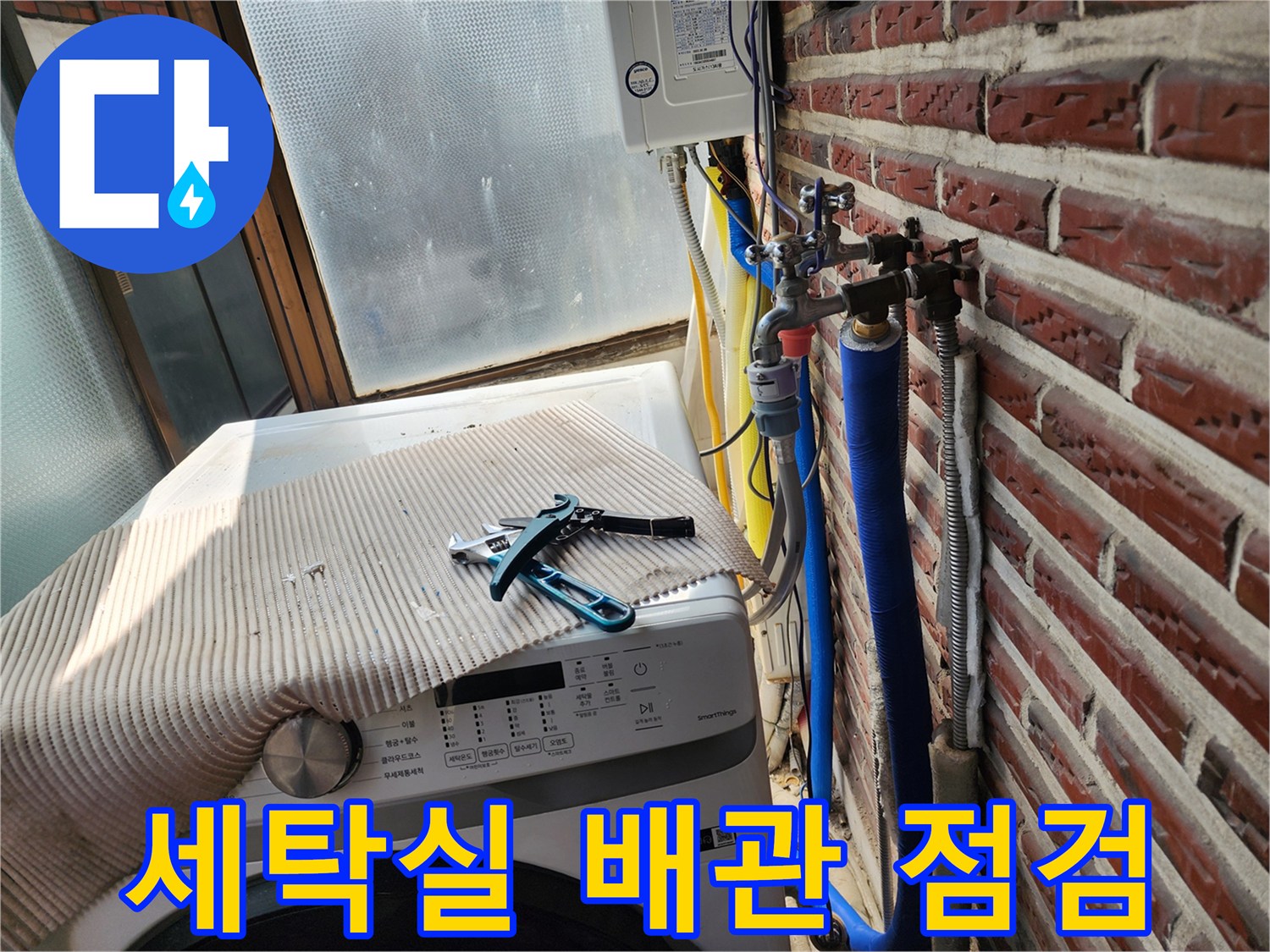 세탁기 옆에 놓인 배관 공구와 외벽 노출 배관 모습