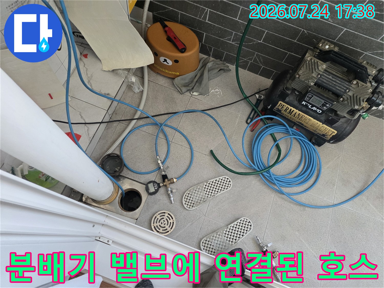 공압 기기와 파란색 호스로 연결된 분배기 시스템 점검 장면