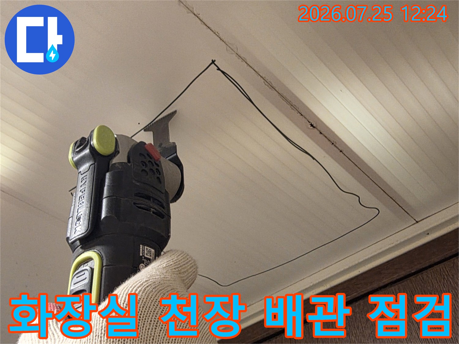 천장 내부를 확인하며 전동공구로 작업 중인 기술자의 모습