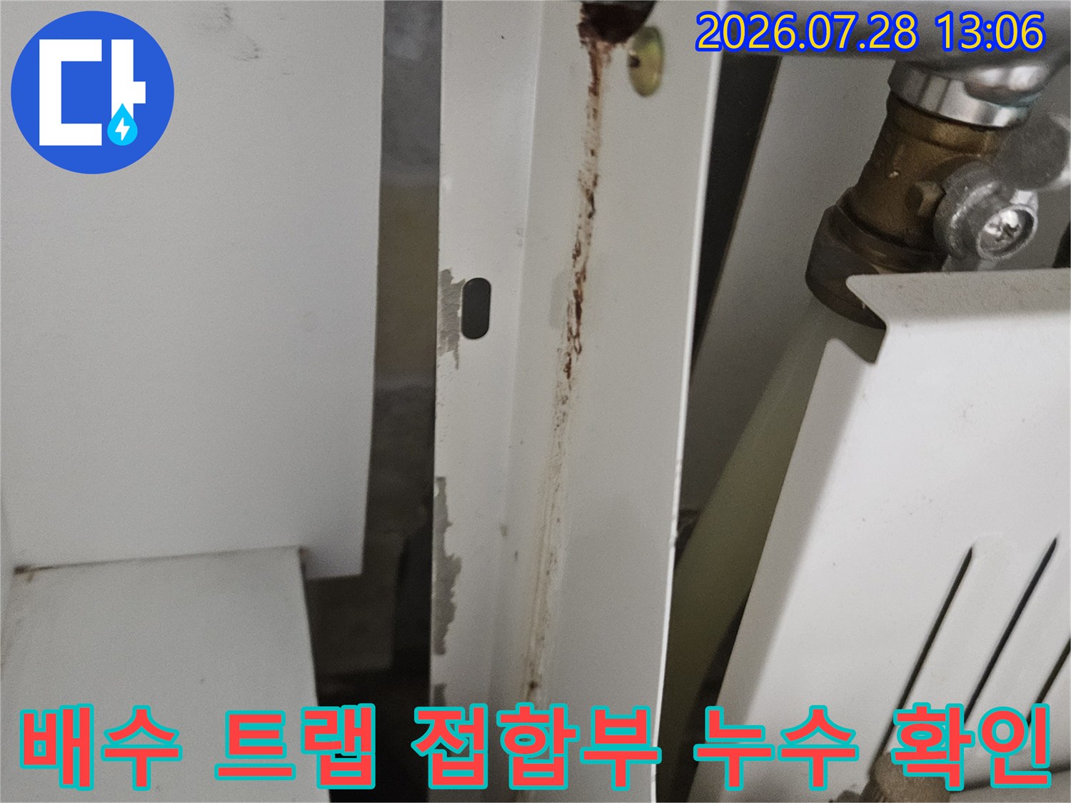 배수 파이프와 고정 장치가 연결된 구간의 누수 여부를 점검하는 장면