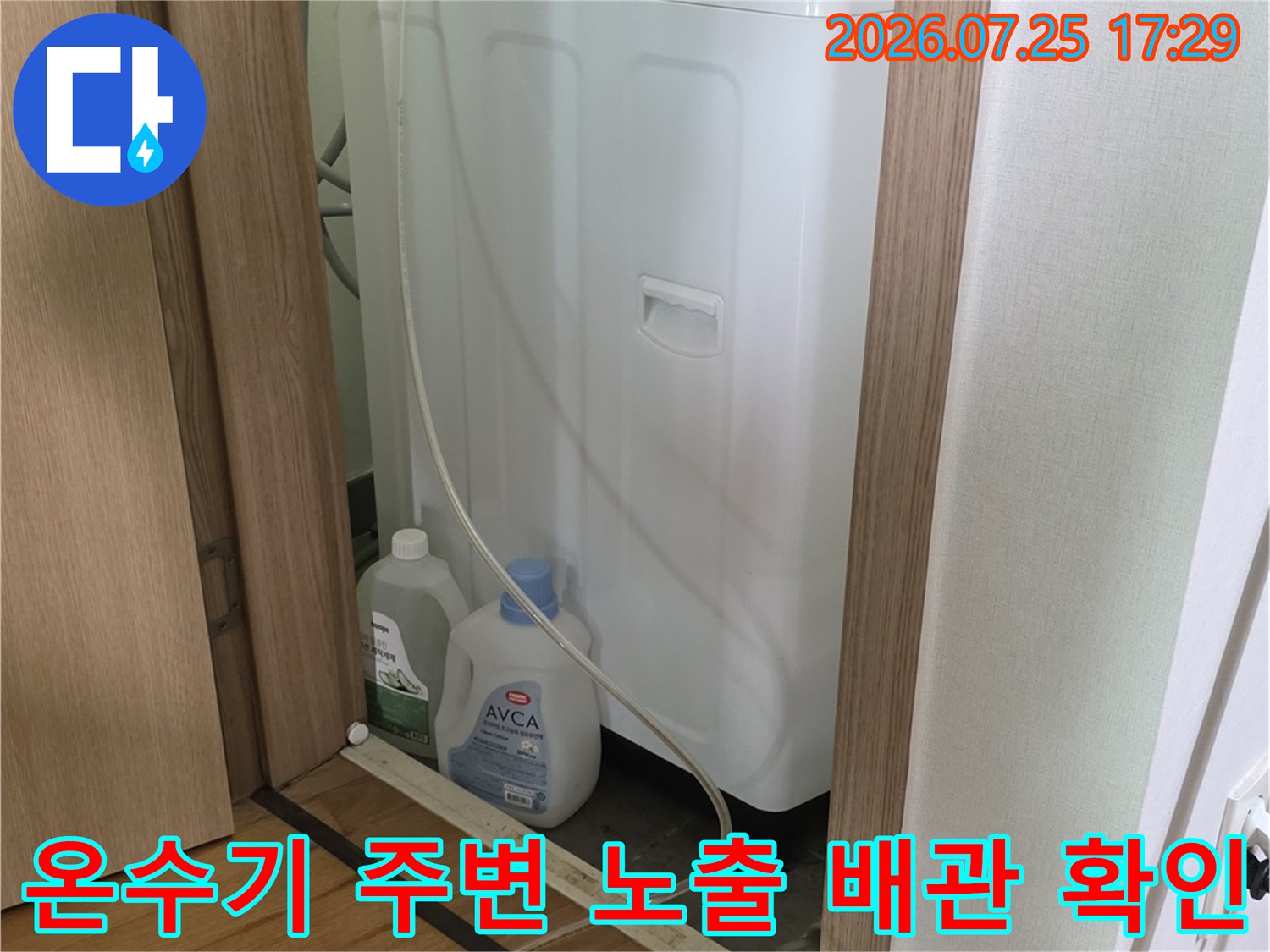 파란색 계량기와 연동된 온수기 옆 수도 배관의 상태를 점검하는 모습